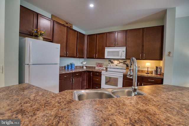 kitchen with white appliances, a sink, and dark brown cabinets