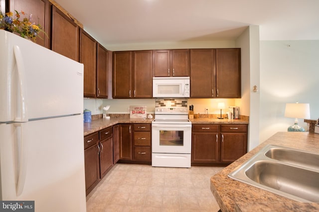 kitchen featuring white appliances and a sink