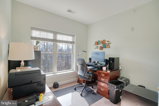 office featuring a healthy amount of sunlight, baseboards, visible vents, and carpet flooring