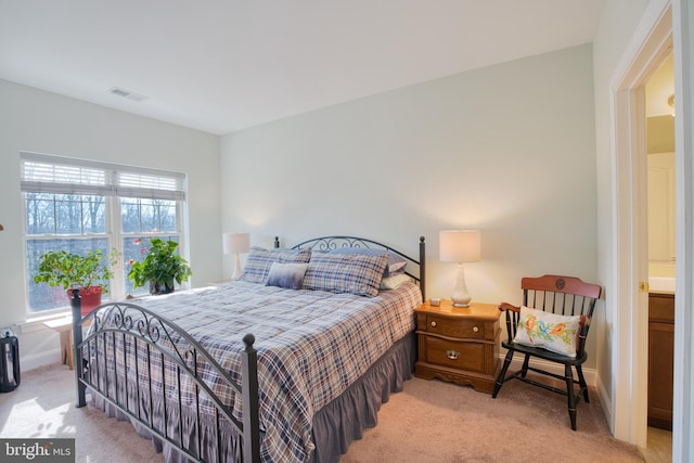 bedroom featuring baseboards, visible vents, and light colored carpet