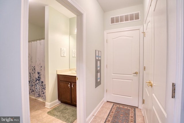 bathroom featuring vanity, baseboards, visible vents, a shower with curtain, and tile patterned floors