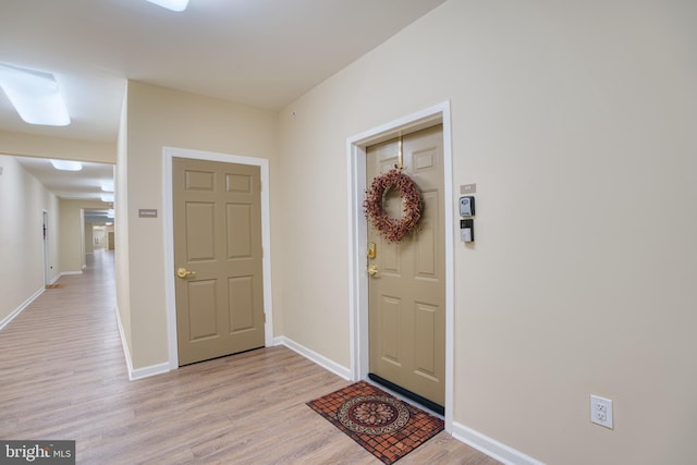 foyer entrance featuring light wood-type flooring and baseboards