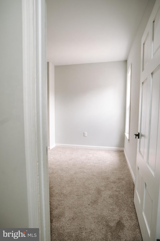 empty room featuring baseboards and carpet flooring