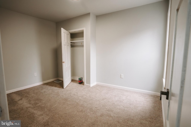 unfurnished bedroom with carpet floors, a closet, and baseboards