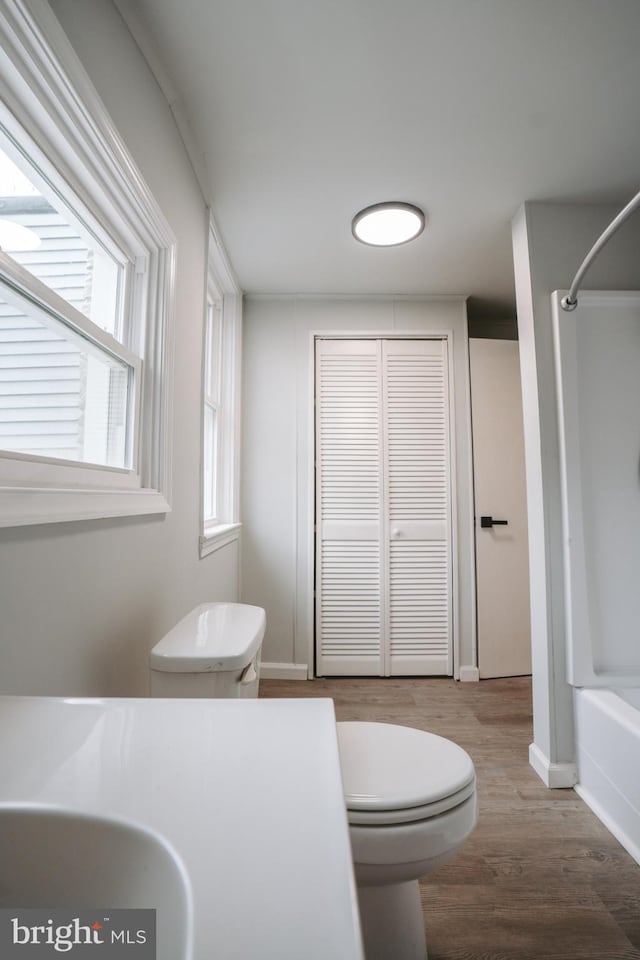 full bathroom with a closet, shower / tub combination, toilet, and wood finished floors