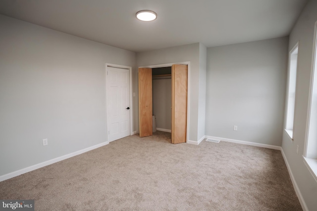 unfurnished bedroom with light carpet and baseboards