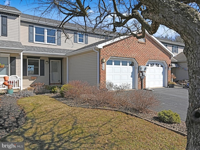 traditional-style house featuring a garage, driveway, and a front lawn