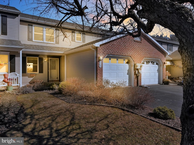 property exterior at dusk with a garage, concrete driveway, and a porch