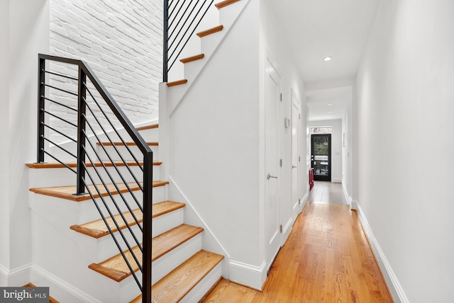 stairway with recessed lighting, wood finished floors, and baseboards