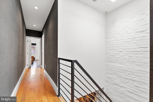 hallway with baseboards, recessed lighting, and light wood-style floors