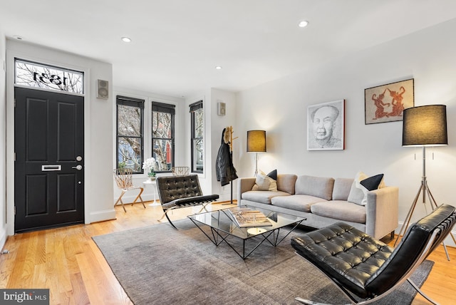 living room with baseboards, recessed lighting, and light wood-style floors