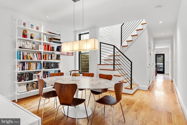 dining room with stairs, light wood-style flooring, and recessed lighting