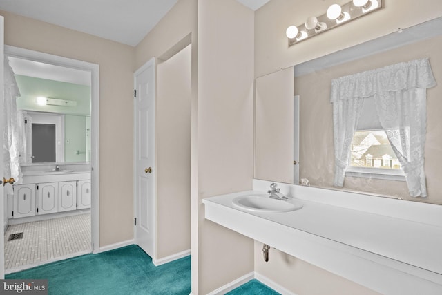 bathroom featuring visible vents, baseboards, and a sink