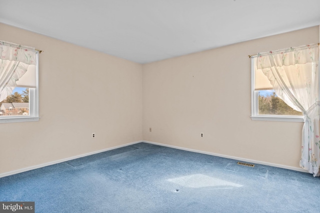 spare room with visible vents, baseboards, and carpet flooring