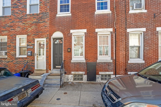 view of exterior entry featuring brick siding