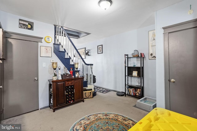 carpeted foyer entrance with stairs and baseboards