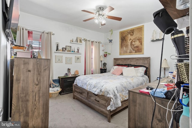 bedroom with a ceiling fan and light colored carpet