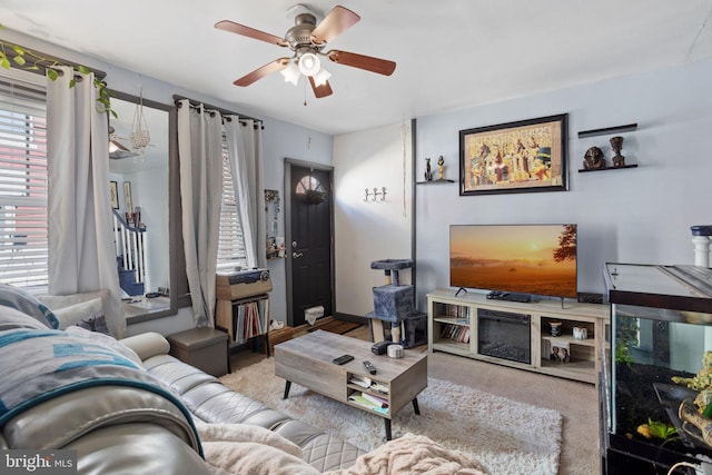 living room featuring carpet and a ceiling fan