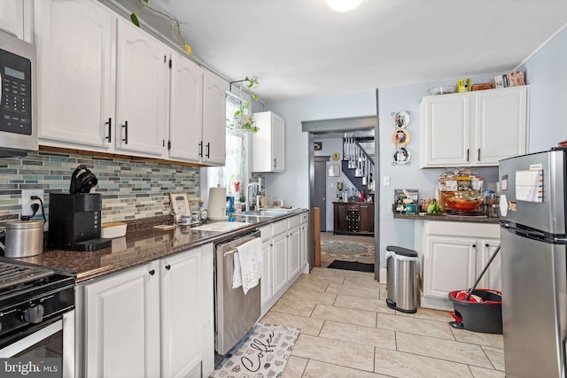 kitchen featuring a sink, white cabinetry, appliances with stainless steel finishes, and backsplash