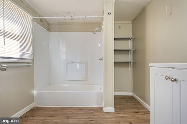 bathroom featuring shower / bath combination, baseboards, wood finished floors, and vanity