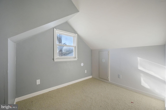 bonus room with light carpet, vaulted ceiling, and baseboards