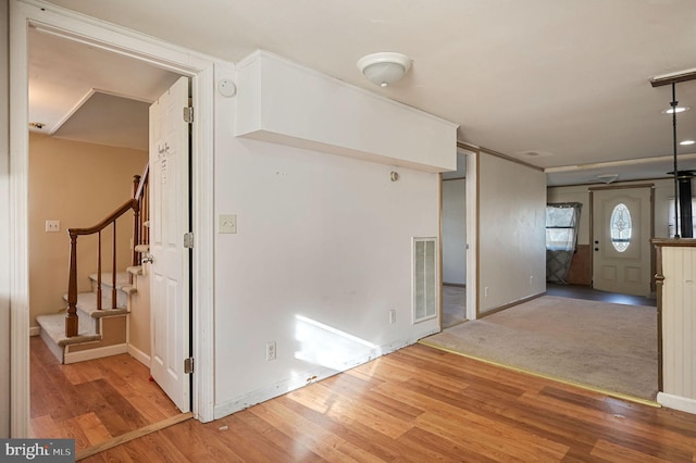 interior space with stairway, wood finished floors, visible vents, and baseboards