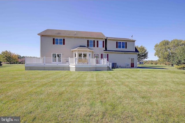 rear view of house featuring a deck and a yard