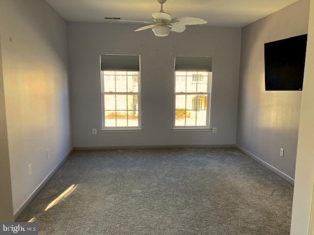 empty room with ceiling fan, baseboards, and carpet flooring