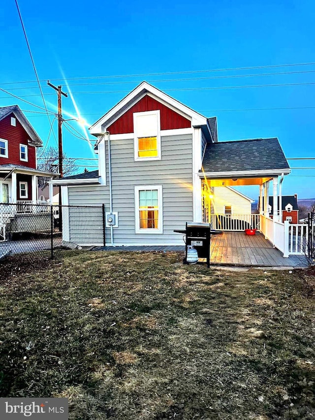 rear view of property featuring fence and a wooden deck