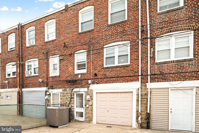 multi unit property featuring central air condition unit, stone siding, and brick siding