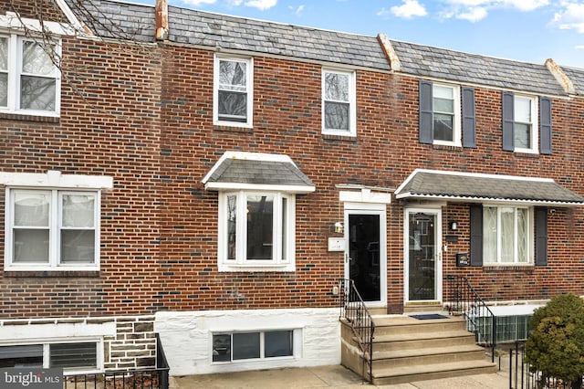 townhome / multi-family property featuring cooling unit and brick siding