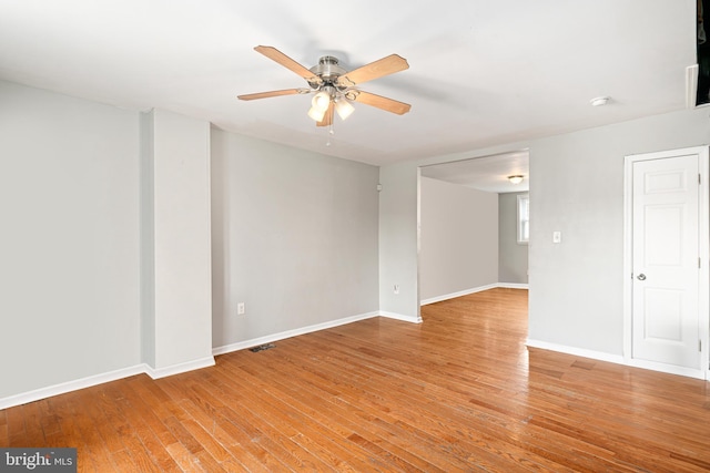 unfurnished room with a ceiling fan, light wood-type flooring, and baseboards