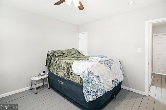 bedroom with ceiling fan, baseboards, and hardwood / wood-style floors