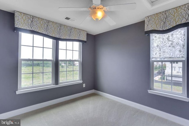 spare room featuring carpet, visible vents, baseboards, and ceiling fan