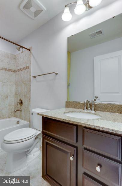 bathroom with toilet, shower / tub combination, visible vents, and vanity