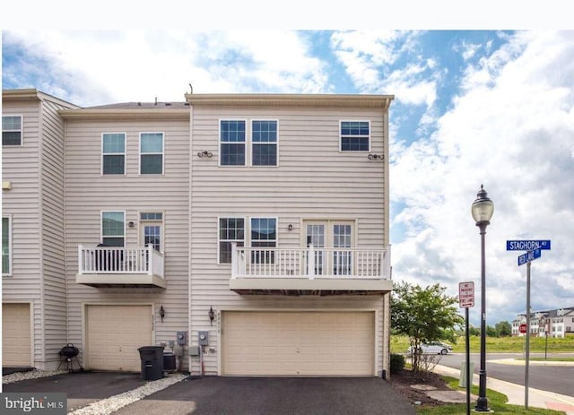 multi unit property featuring driveway and an attached garage