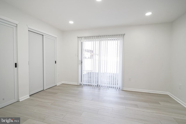 unfurnished bedroom with baseboards, access to outside, recessed lighting, and light wood-style floors