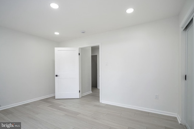 unfurnished bedroom featuring baseboards, light wood-type flooring, and recessed lighting