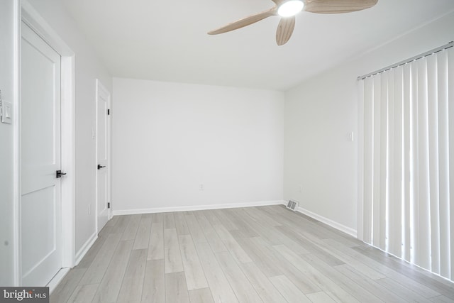 empty room featuring ceiling fan, light wood-type flooring, visible vents, and baseboards