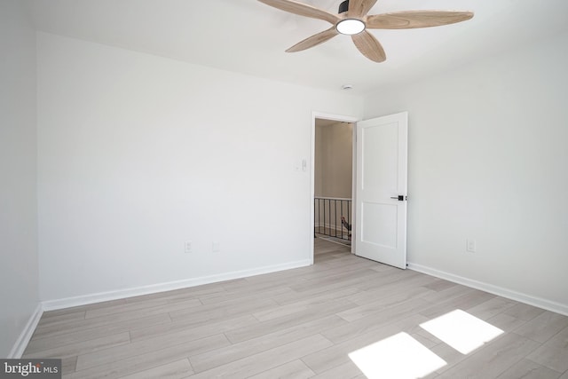 unfurnished room with a ceiling fan, baseboards, and light wood finished floors