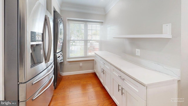 130 Saint Charles Sq Unit 130, Sterling, VA 20164 - kitchen featuring crown molding, white cabinets, stacked washer / drying machine, baseboards, and stainless steel fridge with ice dispenser