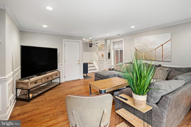 living area featuring light wood finished floors, stairway, ornamental molding, and recessed lighting