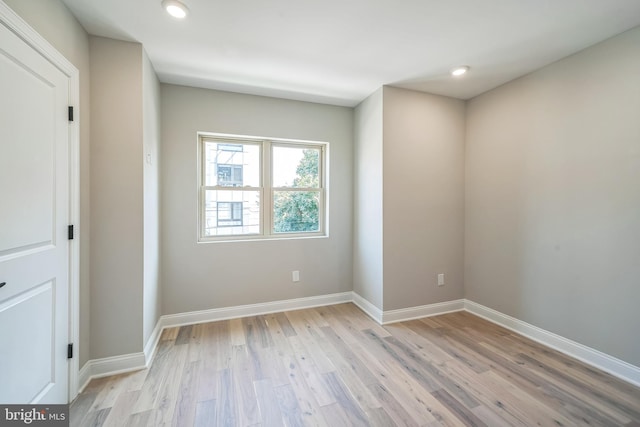 empty room featuring light wood-type flooring, baseboards, and recessed lighting