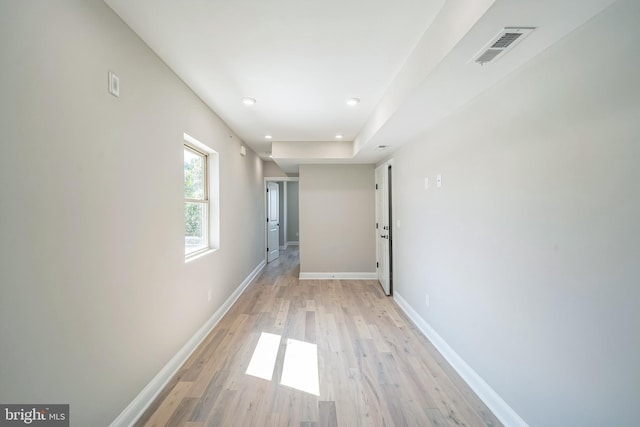 hall featuring light wood-type flooring, baseboards, visible vents, and recessed lighting