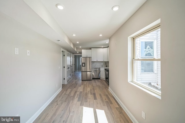 kitchen with baseboards, appliances with stainless steel finishes, white cabinets, and recessed lighting