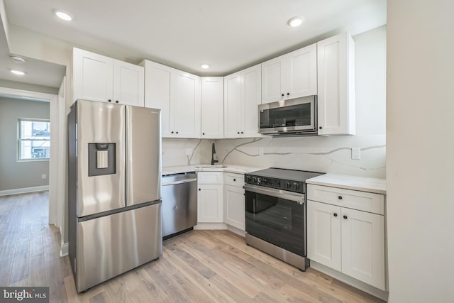 kitchen with white cabinetry, appliances with stainless steel finishes, and backsplash