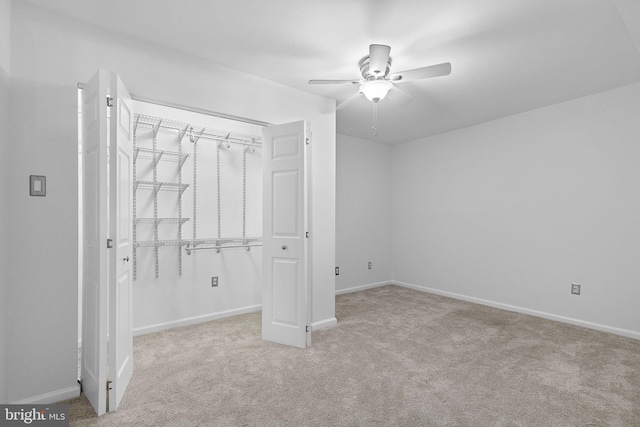 unfurnished bedroom with carpet floors, a closet, ceiling fan, and baseboards