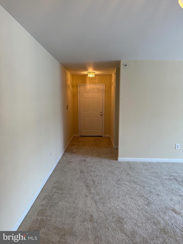 spare room featuring carpet floors and baseboards