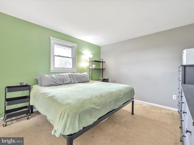 bedroom featuring light carpet and baseboards