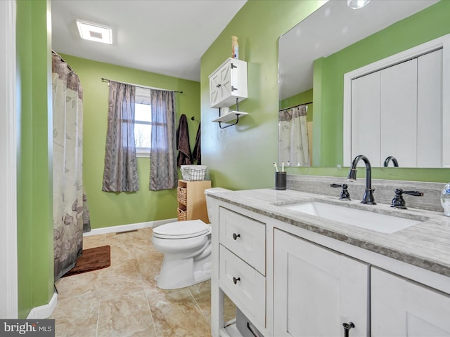 full bath with toilet, vanity, and baseboards